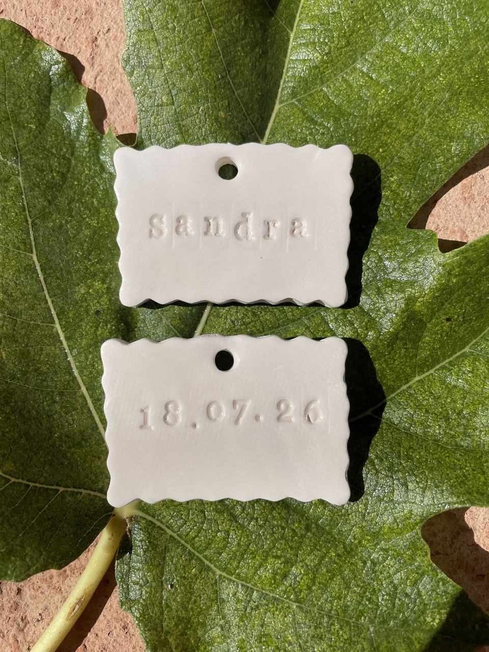 Dos etiquetas con nombre y fecha sobre una hoja